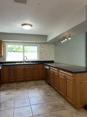 a kitchen with stainless steel appliances granite countertop a sink and a stove