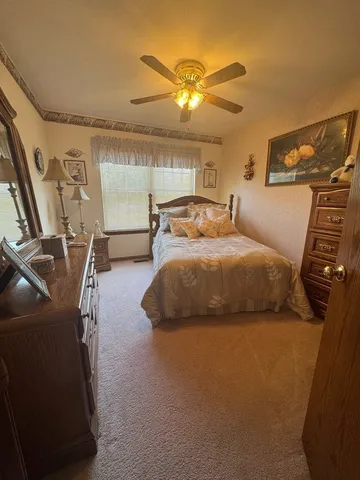 a bedroom with a bed and a flat tv screen on dresser