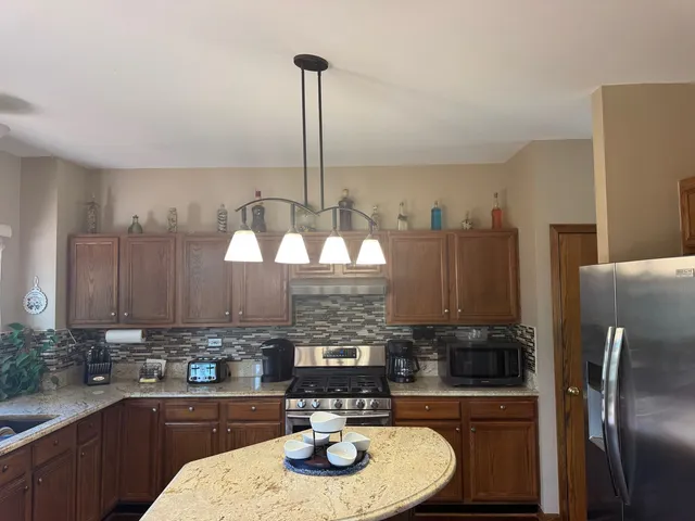 a kitchen with granite countertop a sink stainless steel appliances and cabinets