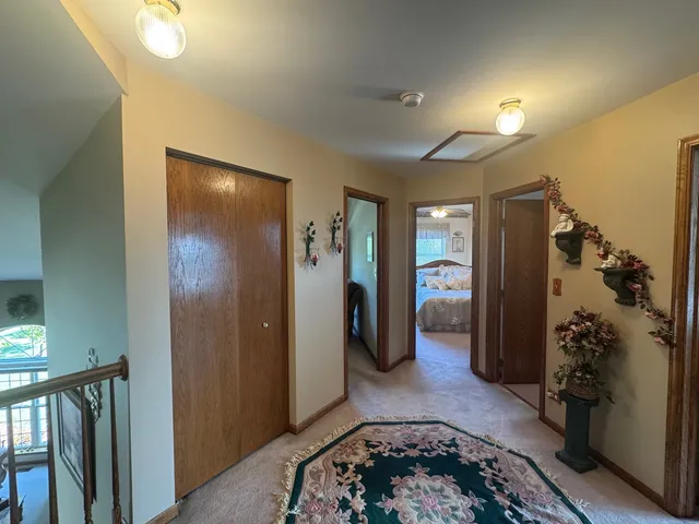 a view of a hallway with closet and a bathroom
