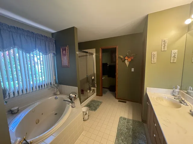 a bathroom with a tub sink and mirror