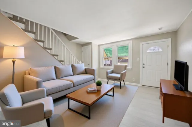 a living room with furniture a flat screen tv and a window