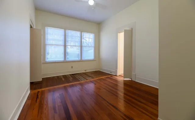wooden floor in an empty room with a window
