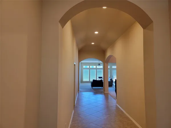 a view of a hallway with wooden floor and a living room