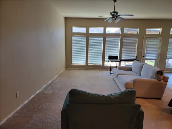 a living room with furniture and a floor to ceiling window