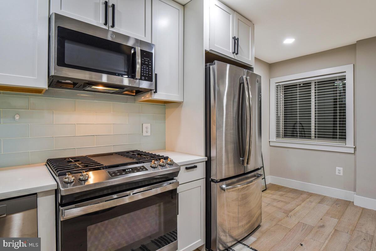 1028 Bladensburg Road Northeast, Unit 5 Washington, DC 20002 - Photo 10 of 29 a kitchen with stainless steel appliances a stove a microwave and a refrigerator