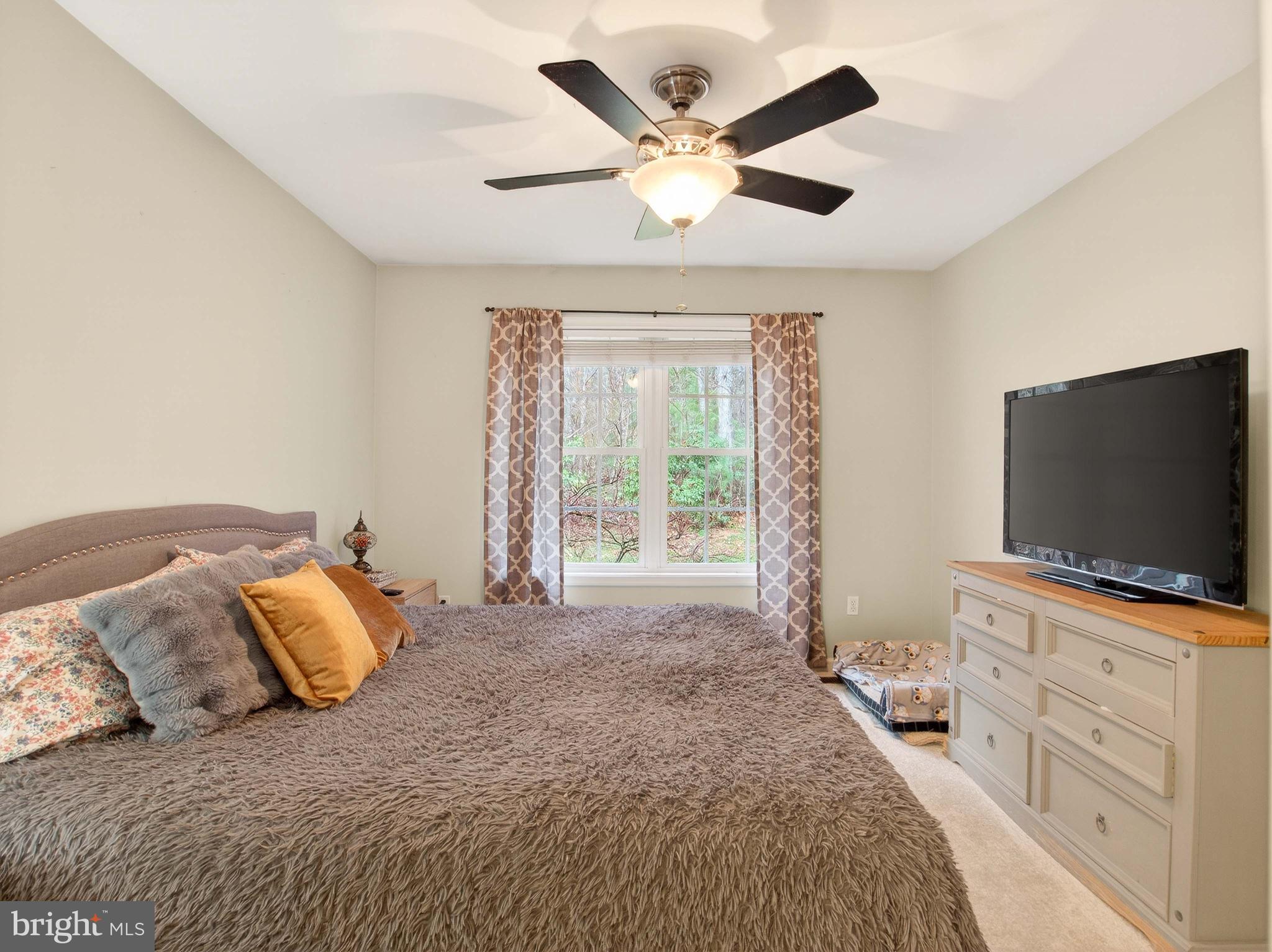 2586 West Hoover Road Haywood, VA 22722 - Photo 18 of 35 a bedroom with a large bed and a flat screen tv