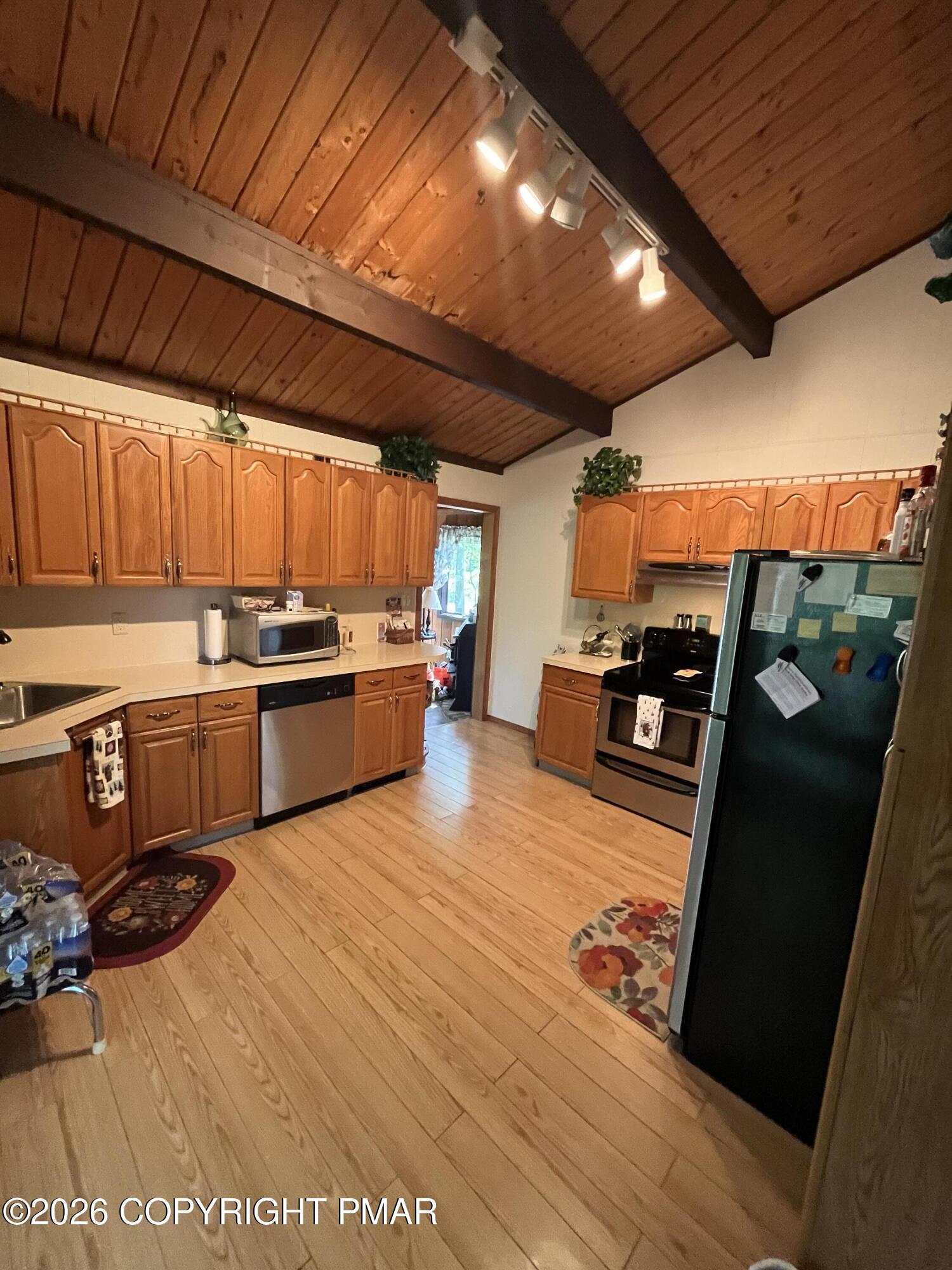 5970 Decker Road Bushkill, PA 18324 - Photo 14 of 26 a kitchen with stainless steel appliances wooden cabinets and a stove top oven
