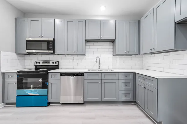 a kitchen with cabinets appliances and a sink