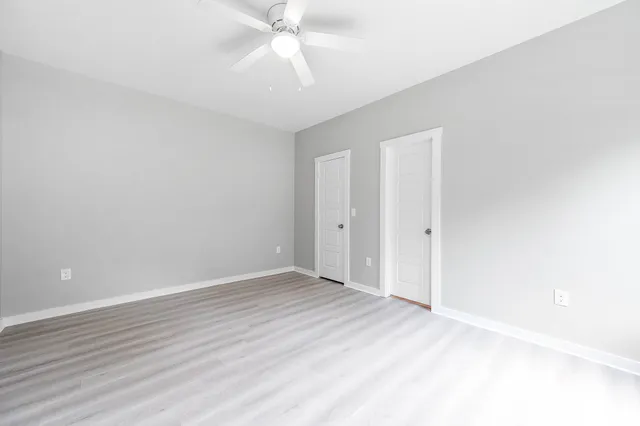 a view of an empty room with wooden floor