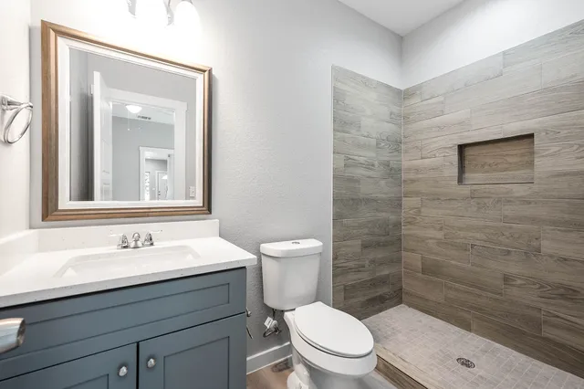 a bathroom with a sink a toilet and shower