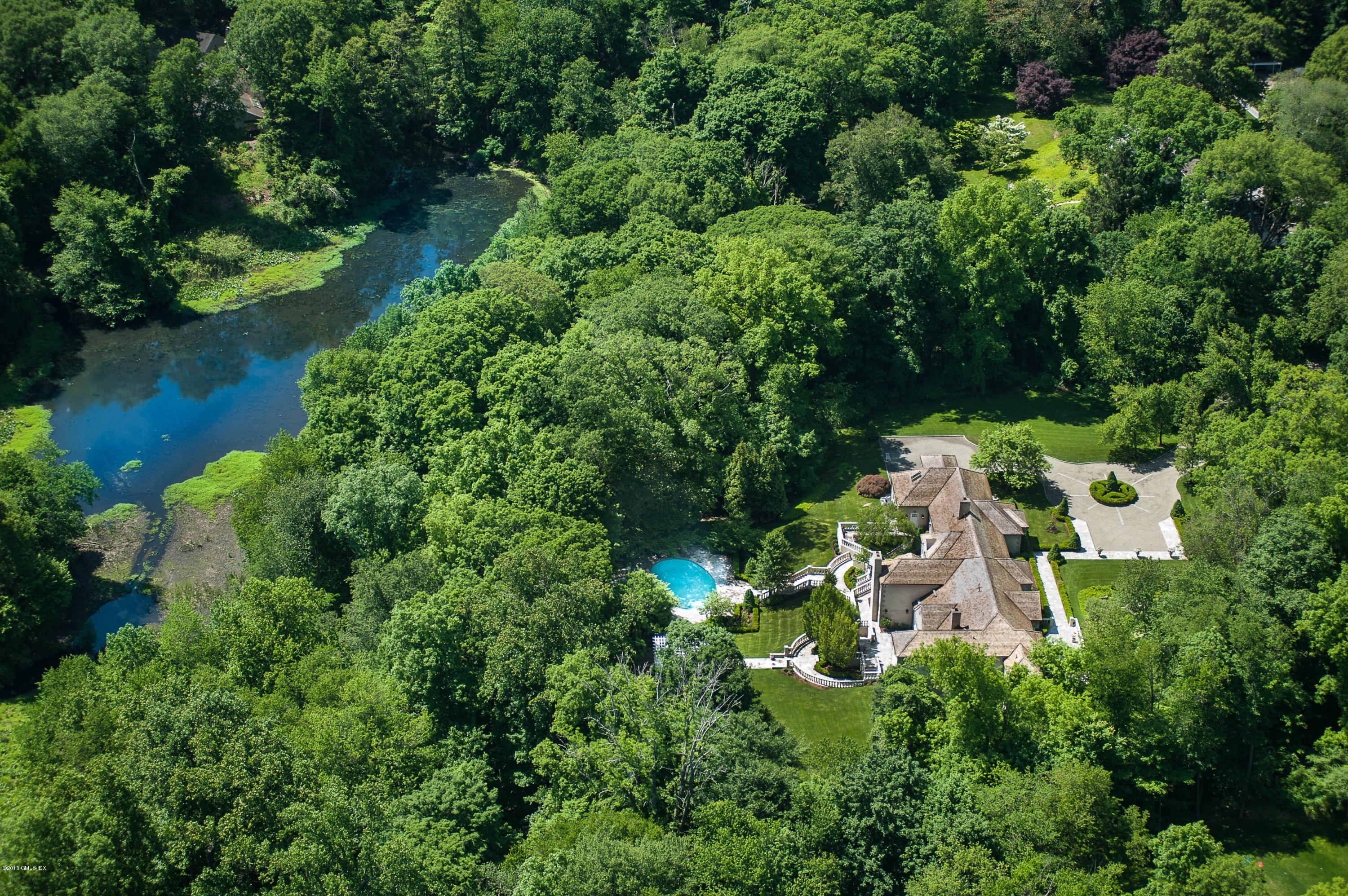 an aerial view of a house with yard outdoor seating and lake view