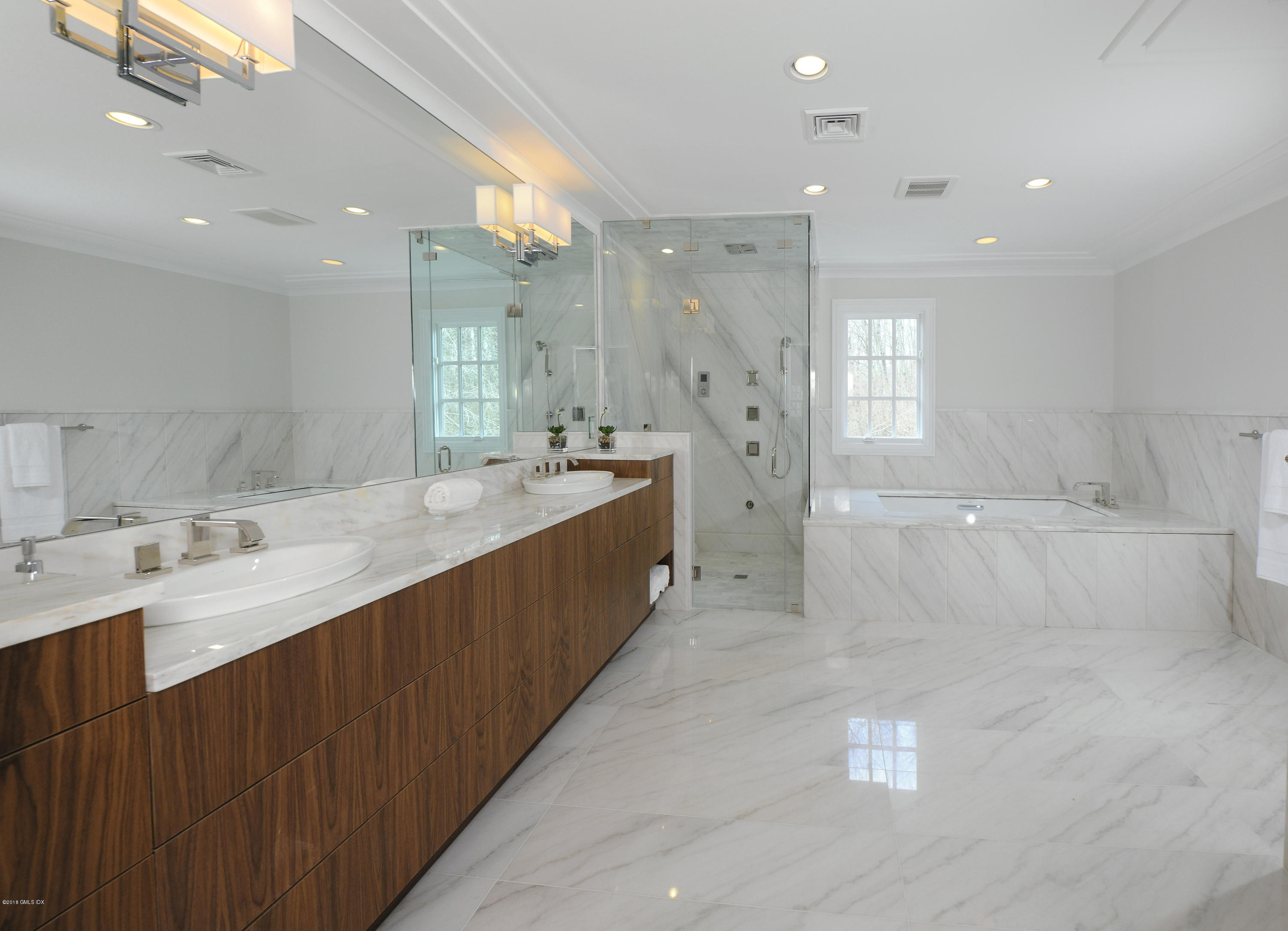 36 Perkins Road Greenwich, CT 06830 - Photo 24 of 26 a bathroom with a double vanity sink a large mirror and shower