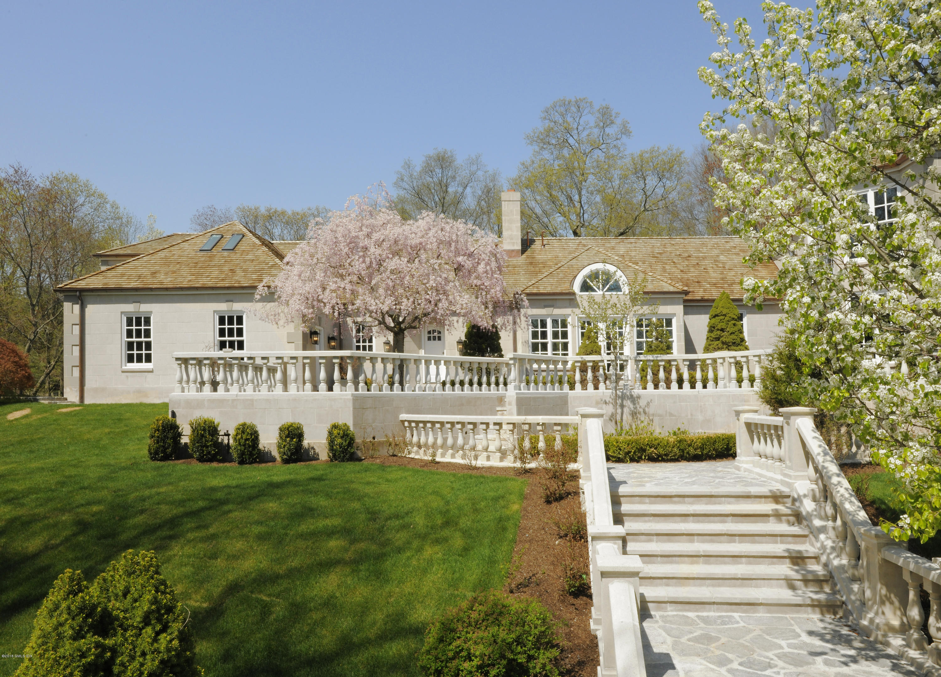 36 Perkins Road Greenwich, CT 06830 - Photo 9 of 26 a front view of a house with a yard table and chairs
