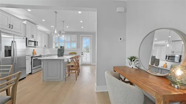a kitchen with a table chairs refrigerator and microwave