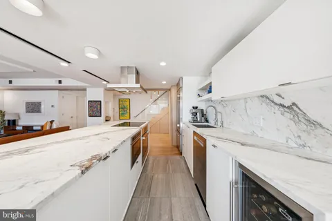 a large kitchen with granite countertop a large counter top sink and stainless steel appliances