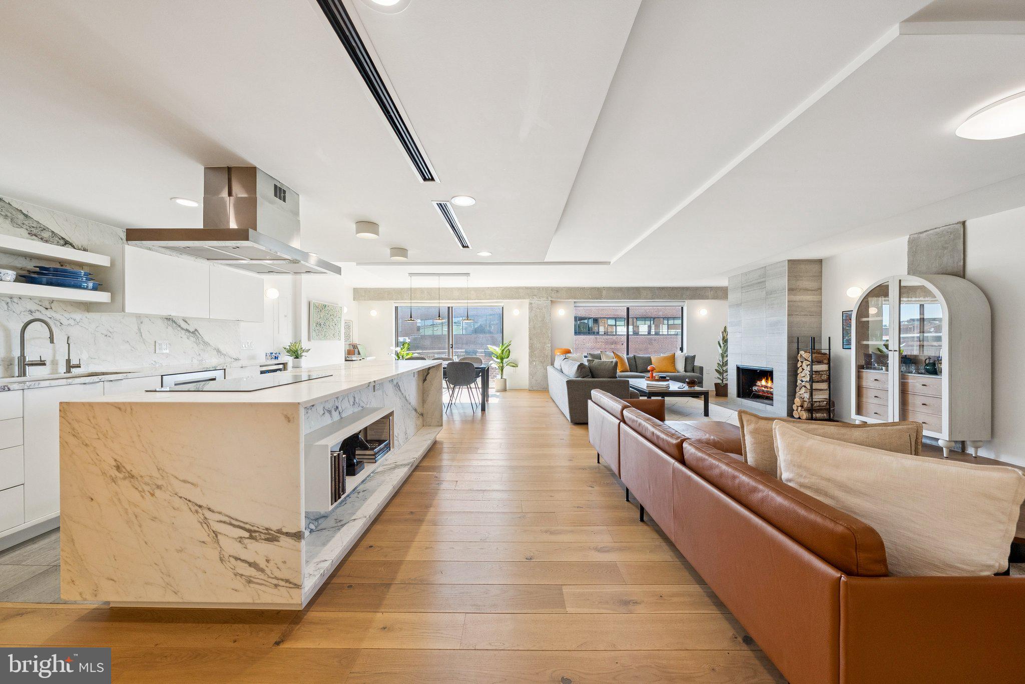 1015 33rd Street Northwest, Unit 809 Washington, DC 20007 - Photo 6 of 39 a large white open kitchen with stainless steel appliances kitchen island granite countertop a large counter top and a stove