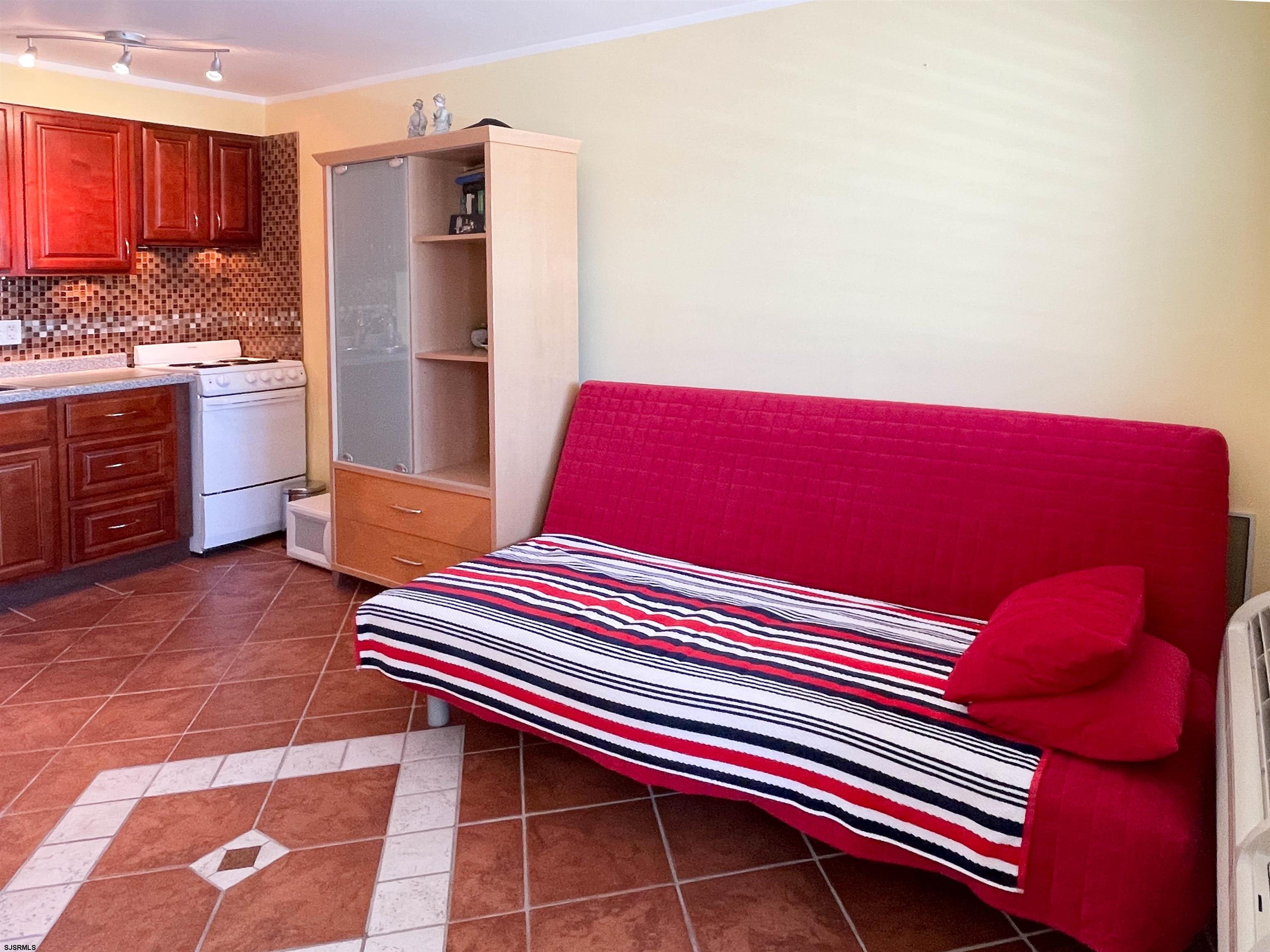 9201 Atlantic Avenue, Unit 2 Margate City, NJ 08402 - Photo 5 of 13 a kitchen with stainless steel appliances a rug and a refrigerator