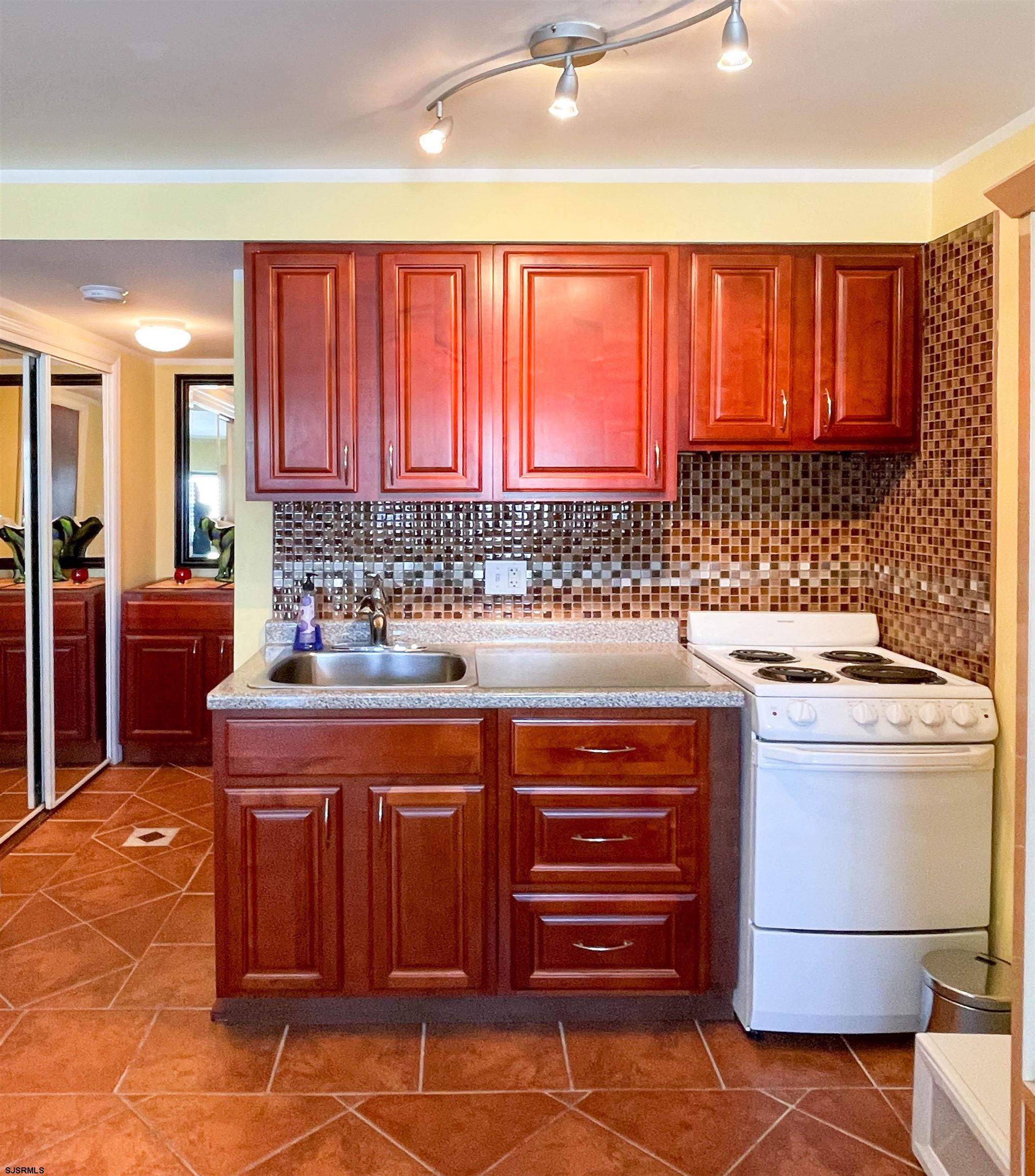 9201 Atlantic Avenue, Unit 2 Margate City, NJ 08402 - Photo 8 of 13 a kitchen with stainless steel appliances granite countertop a stove a sink and a refrigerator