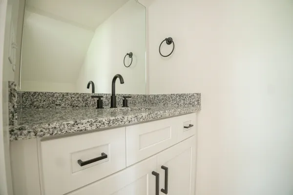 a bathroom with a granite countertop sink and a mirror