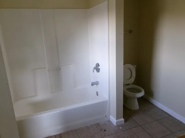 a bathroom with a granite countertop bathtub