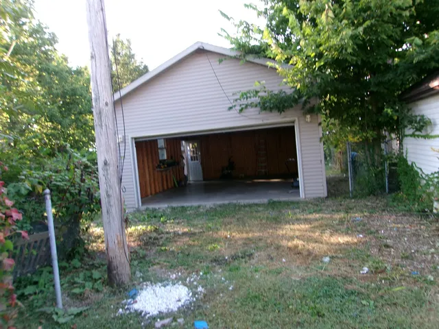 a view of a house with a yard and a tree