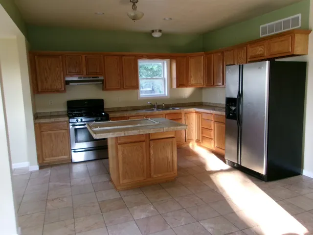 a kitchen with stainless steel appliances granite countertop a stove a refrigerator and a sink