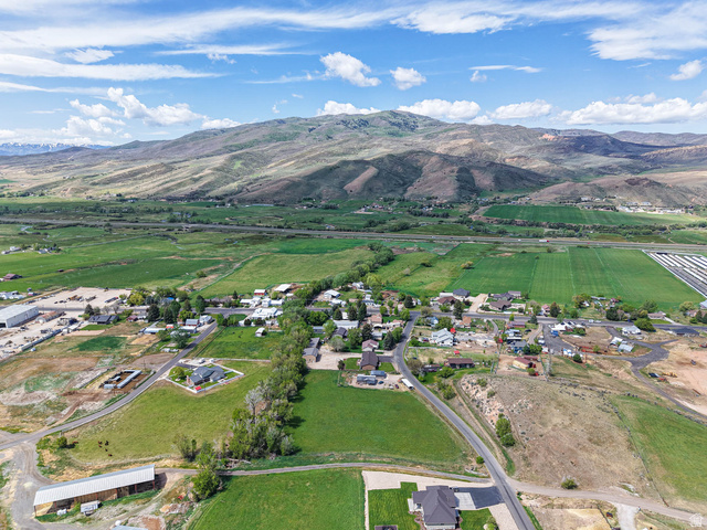 94 Spring Canyon Road Coalville, UT 84017 - Photo 24 of 50 Expansive green landscape featuring distant mountains and a residential area with varied lot sizes