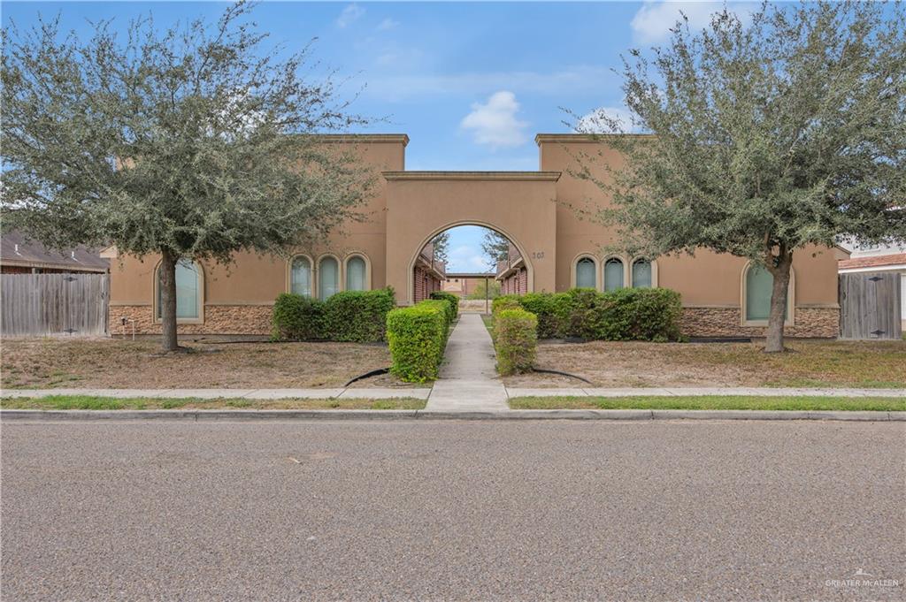a view of a house with a yard and a large tree