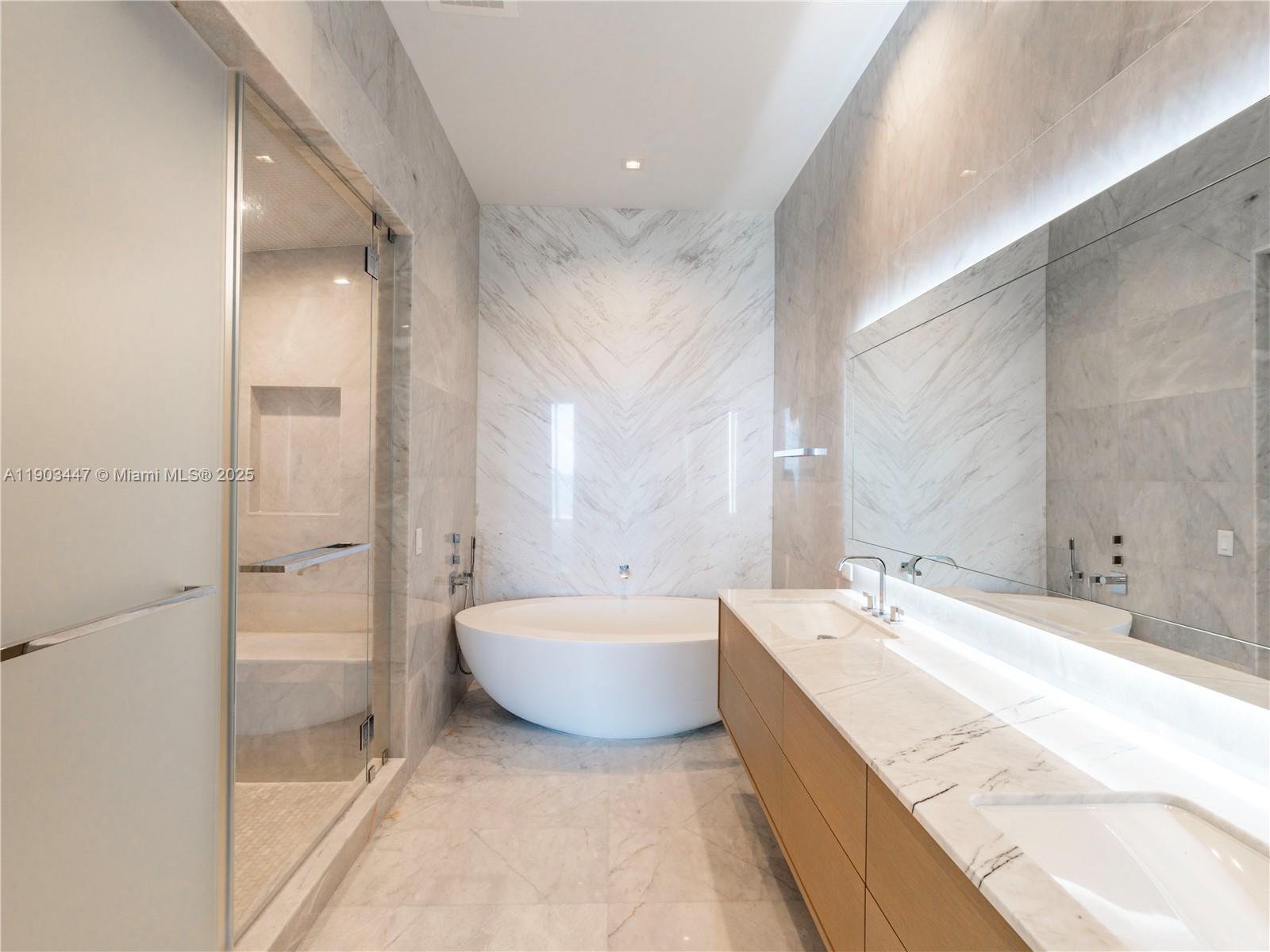 18501 Collins Avenue, Unit 1501 Sunny Isles Beach, FL 33160 - Photo 12 of 35 a spacious bathroom with a tub sink and mirror