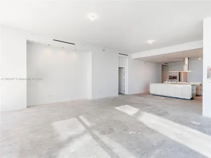 a spacious bedroom with a bed and a chandelier