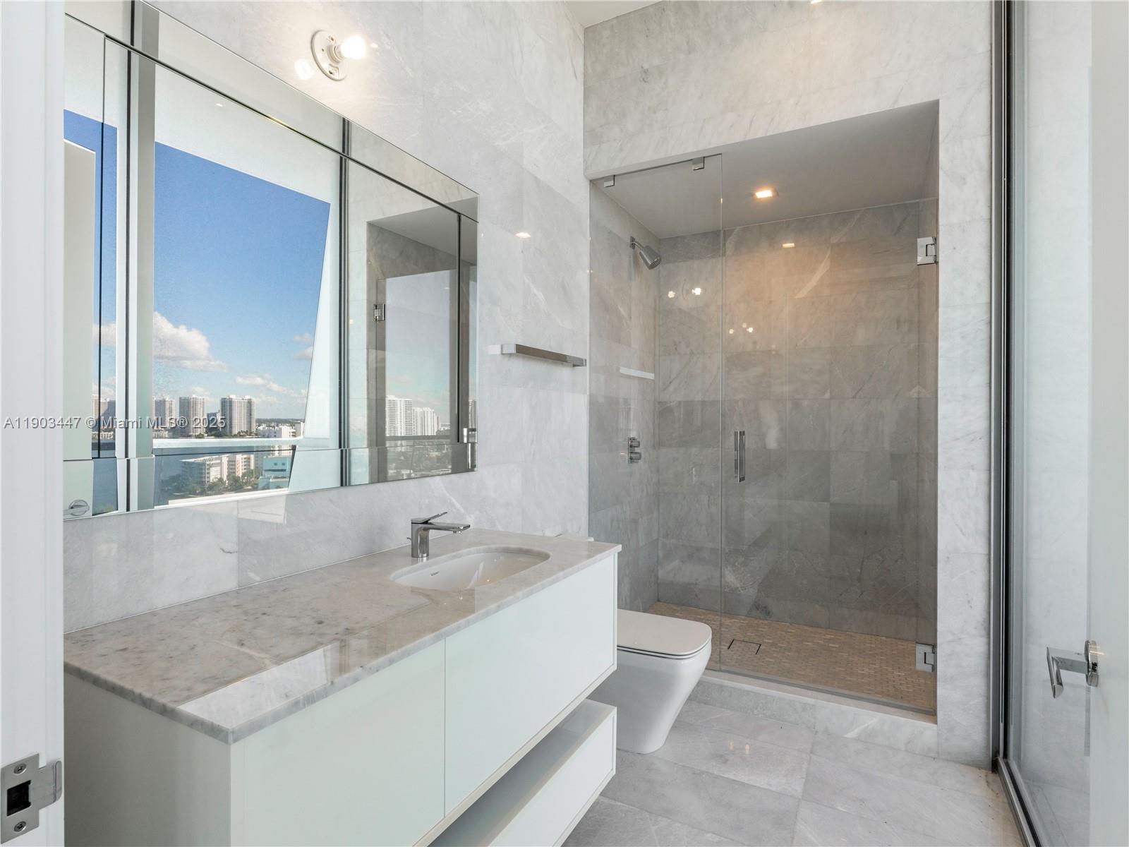 18501 Collins Avenue, Unit 1501 Sunny Isles Beach, FL 33160 - Photo 15 of 35 a bathroom with a granite countertop sink mirror and shower