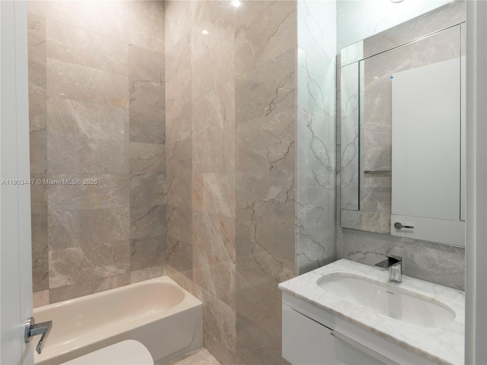 18501 Collins Avenue, Unit 1501 Sunny Isles Beach, FL 33160 - Photo 16 of 35 a bathroom with a sink and a bathtub