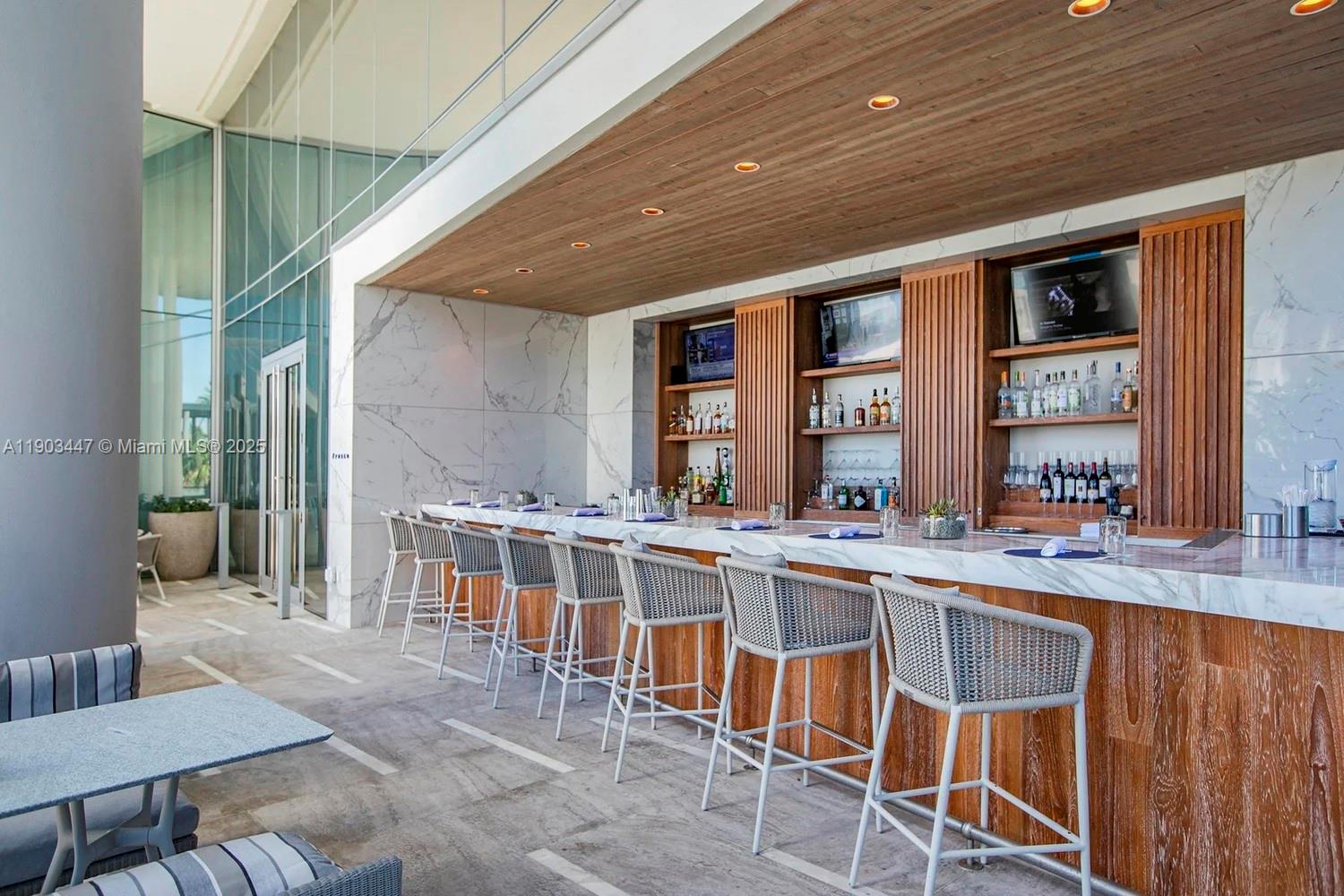 18501 Collins Avenue, Unit 1501 Sunny Isles Beach, FL 33160 - Photo 26 of 35 a kitchen with a table chairs stove and cabinets