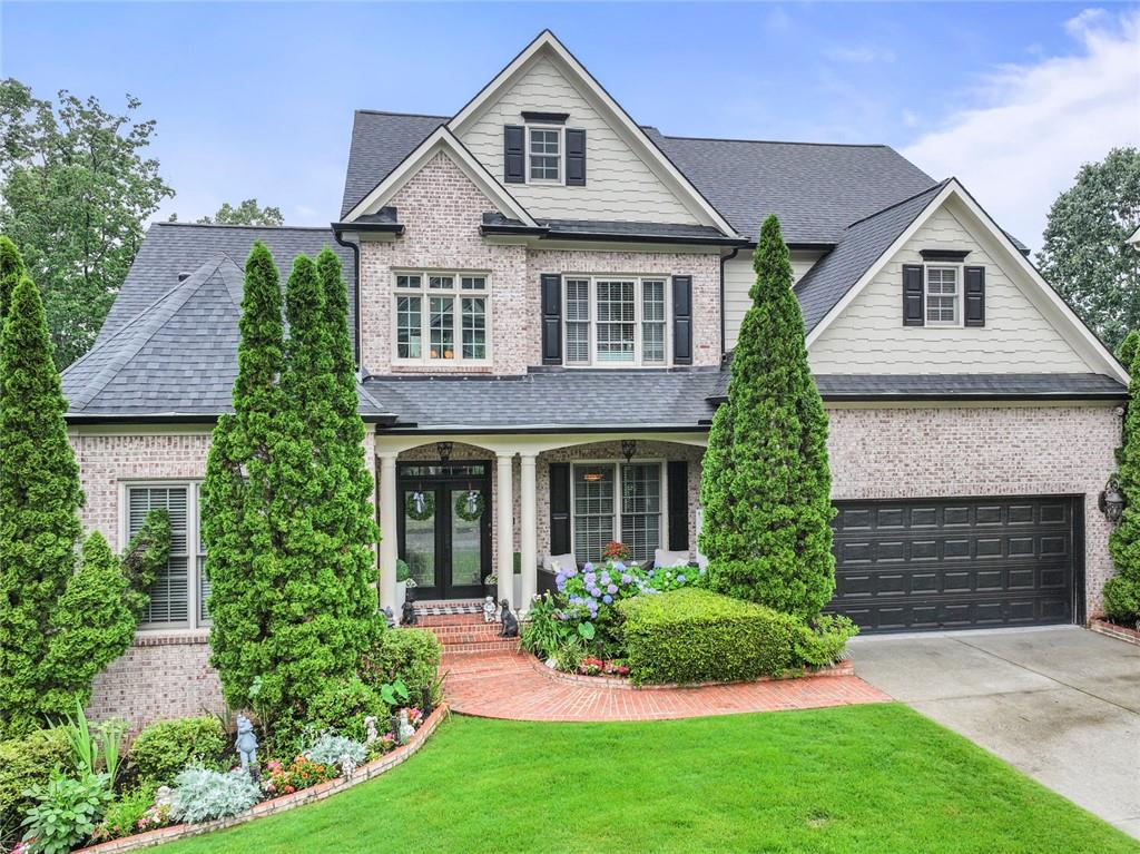 7060 Summit Ridge Chase Cumming, GA 30041 - Photo 1 of 58 a front view of a house with a yard and garage