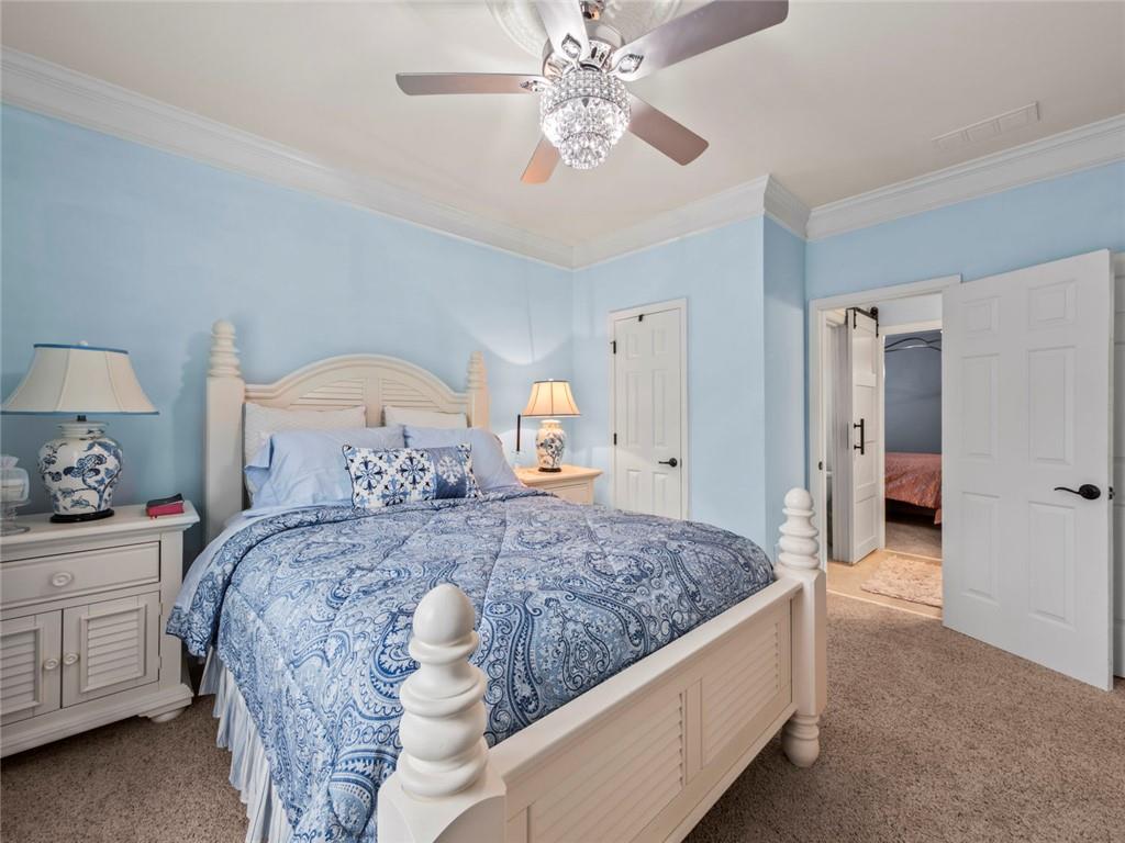 7060 Summit Ridge Chase Cumming, GA 30041 - Photo 26 of 58 a bedroom with a large bed and a chandelier