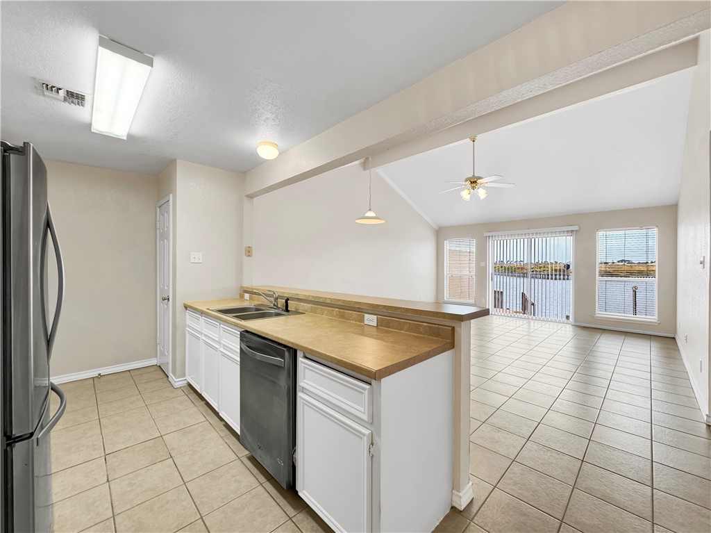 14302 Cruiser Street, Unit B Corpus Christi, TX 78418 - Photo 12 of 25 a kitchen with a stove a refrigerator and a sink