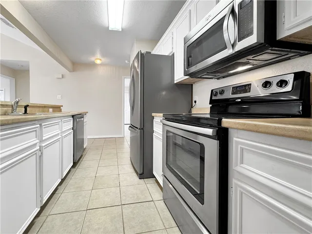 a kitchen with stainless steel appliances granite countertop a stove and a refrigerator