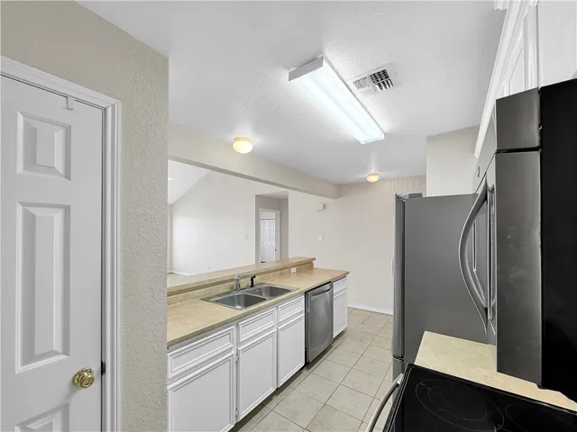 a large kitchen with a refrigerator and a sink