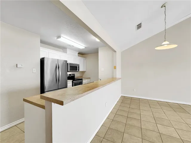a kitchen with stainless steel appliances a refrigerator sink and microwave
