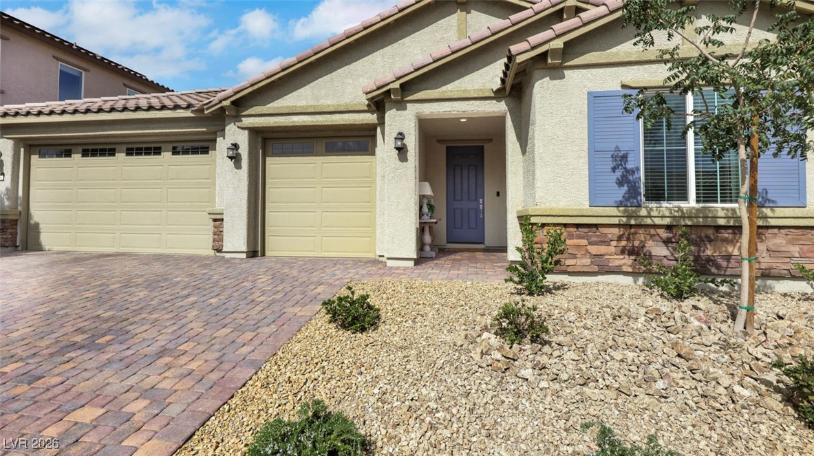 1094 Langston Ranch Avenue Henderson, NV 89002 - Photo 11 of 70 View of front facade with stucco siding, decorative driveway, a garage, and a tile roof