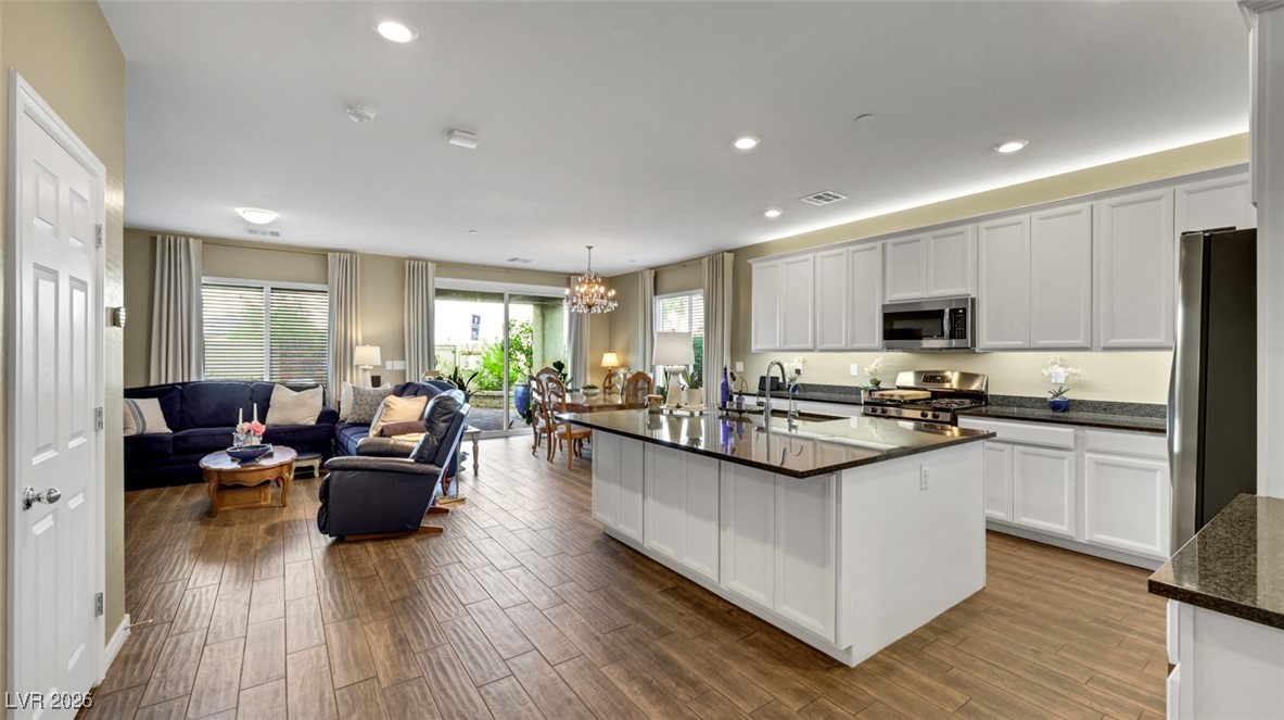 1094 Langston Ranch Avenue Henderson, NV 89002 - Photo 69 of 70 Kitchen featuring white cabinets, appliances with stainless steel finishes, dark wood finished floors, open floor plan, and recessed lighting