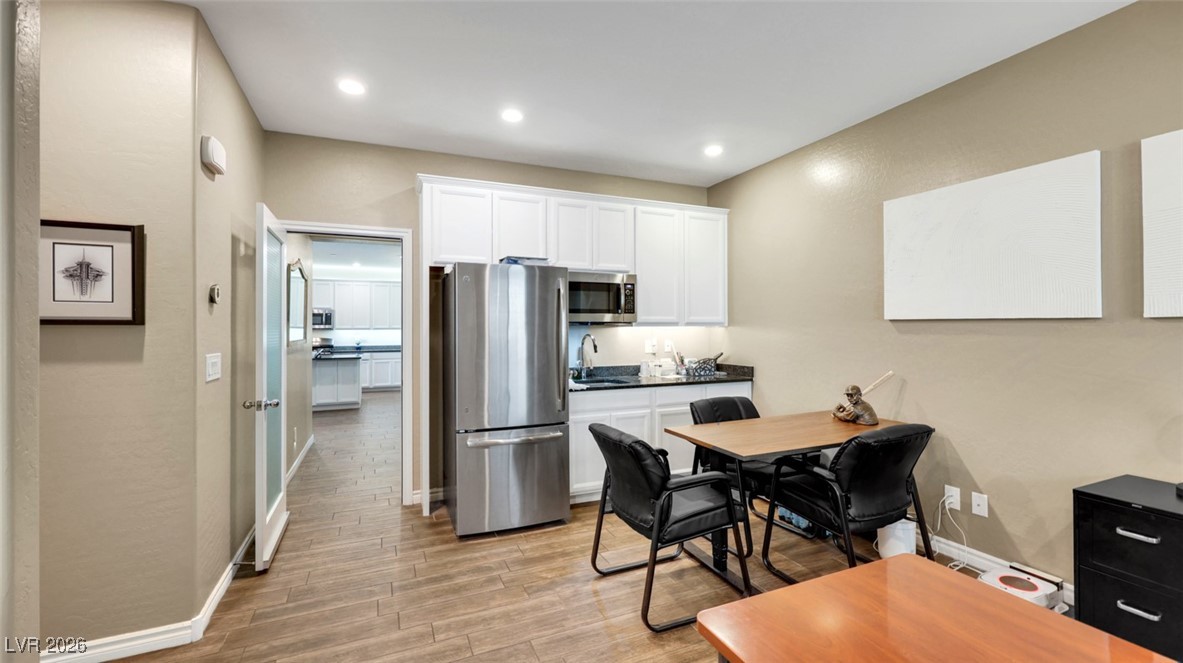 1094 Langston Ranch Avenue Henderson, NV 89002 - Photo 37 of 70 Kitchen with stainless steel appliances, white cabinetry, wood tiled floors, dark countertops, and recessed lighting