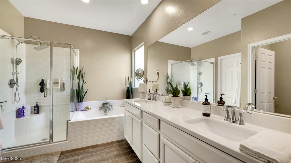 1094 Langston Ranch Avenue Henderson, NV 89002 - Photo 46 of 70 Bathroom featuring a stall shower, wood finish floors, double vanity, a bath, and recessed lighting