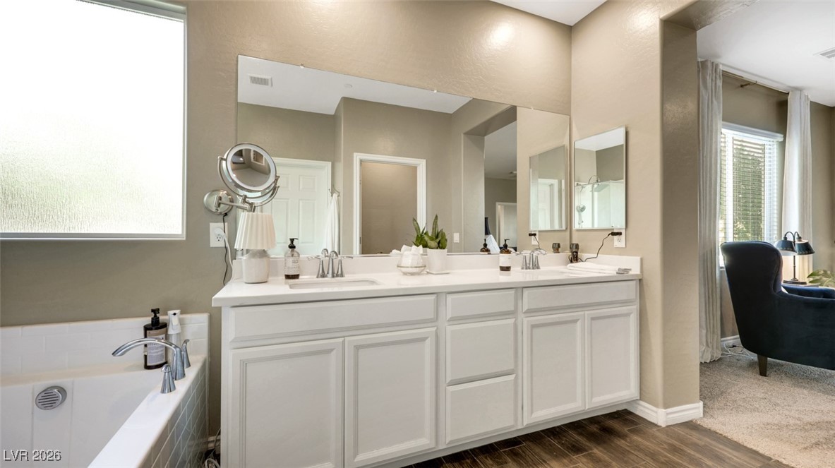 1094 Langston Ranch Avenue Henderson, NV 89002 - Photo 48 of 70 Bathroom with double vanity, dark wood-style floors, and a garden tub