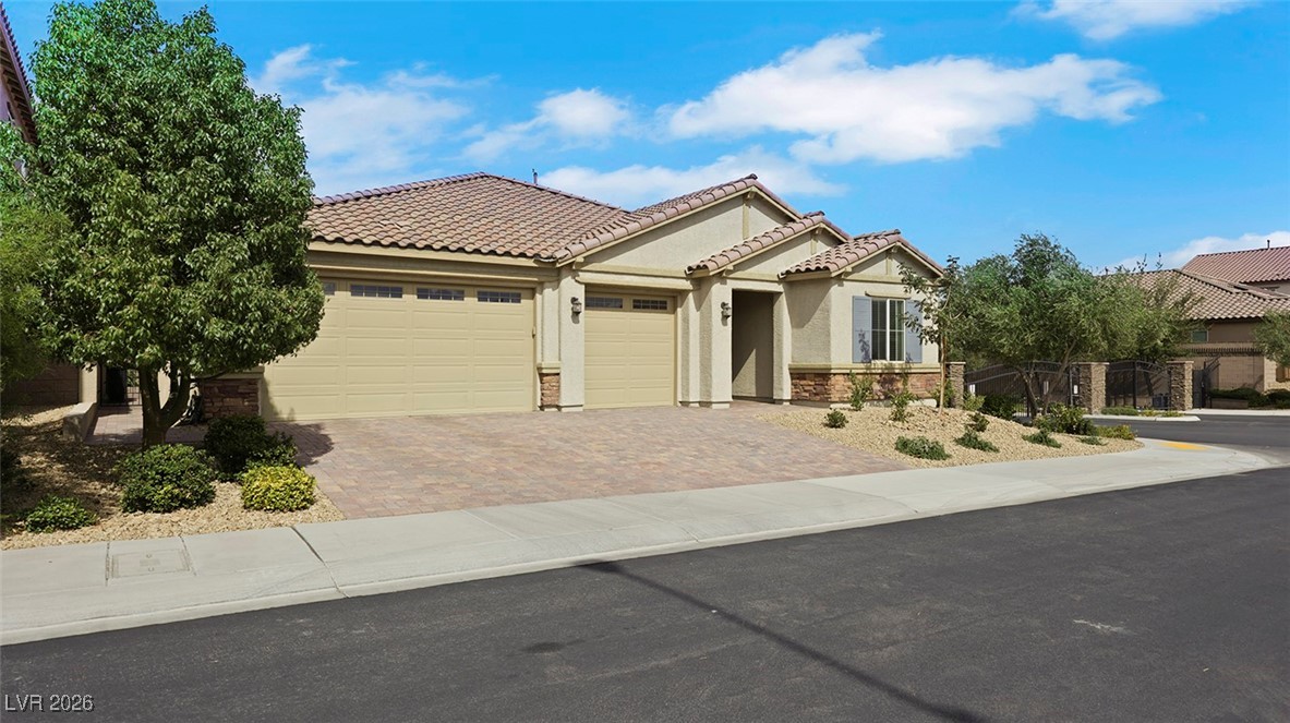 1094 Langston Ranch Avenue Henderson, NV 89002 - Photo 9 of 70 View of front facade featuring stucco siding, decorative driveway, a tile roof, and an attached garage