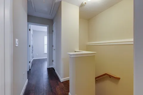a view of a hallway with wooden floor