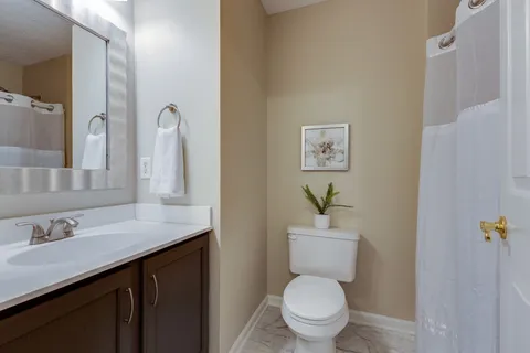 a bathroom with a granite countertop toilet sink and a mirror