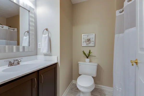 a bathroom with a granite countertop toilet sink and a mirror