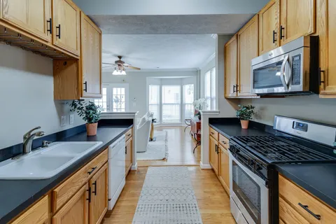 a kitchen with stainless steel appliances granite countertop a sink stove and cabinets